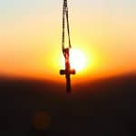 selective focus photography of cross pendant